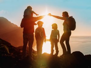 An image of a family hiking trip at Hawaii Volcanoes National Park UNESCO World Heritage Site in Hawaii, the father and mother are holding hands and they have their 3 kids with them